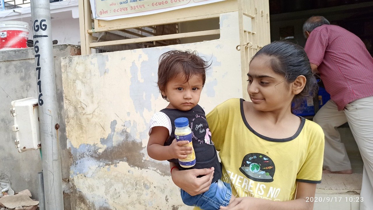 Young girl caring for toddler with milk