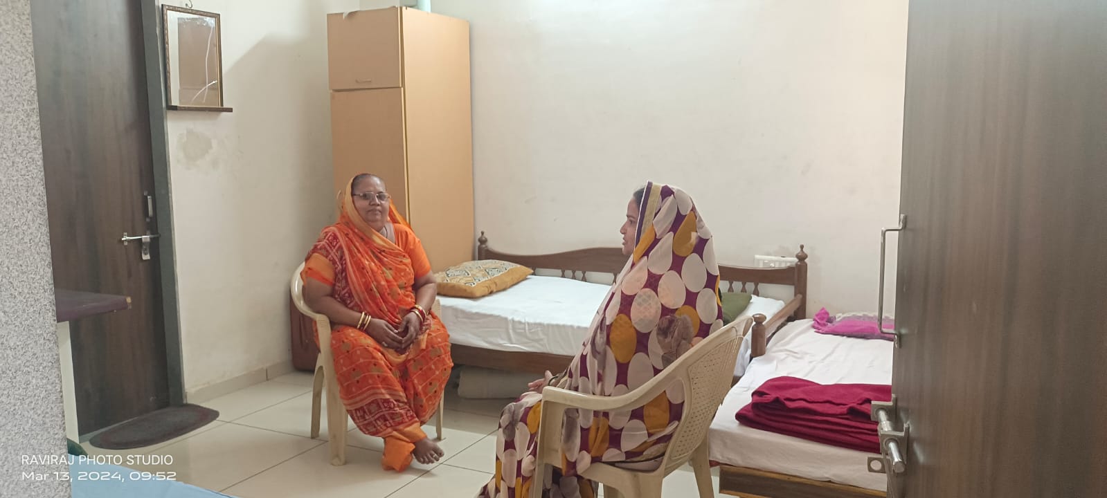 Two elderly women chatting in their room